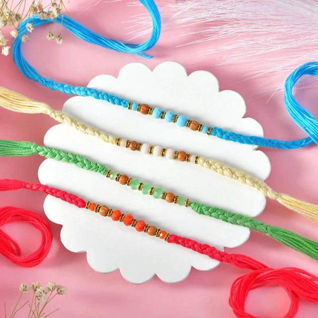 Vibrant Hand-Braided Rakhi Quad with Festive Besan Laddu Box