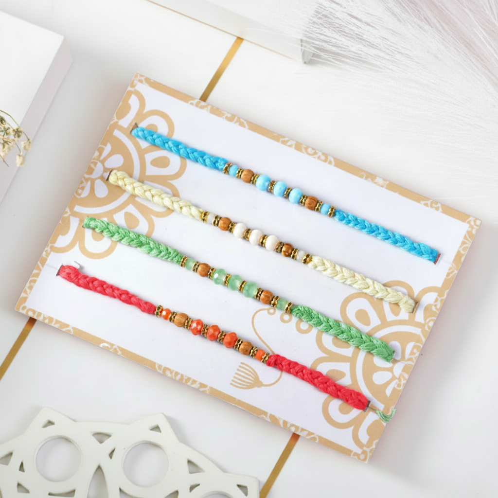Detailed rakhi bracelets presented on a card with beige detailing in a white and gold studio setting